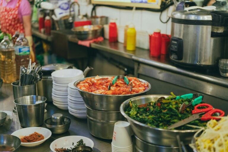 Colorful display of traditional Korean dishes in a bustling Seoul market setting.