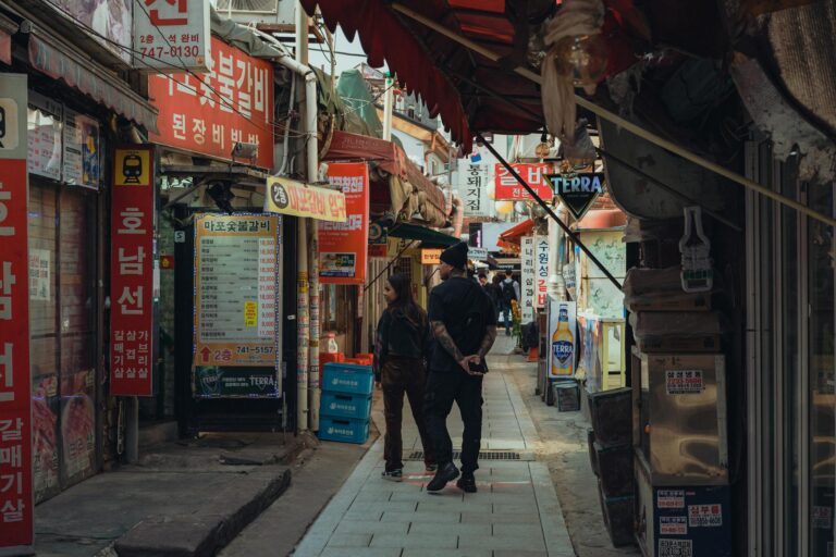 Explore the lively alleyways of a bustling Seoul market, filled with local shops and vibrant signs.